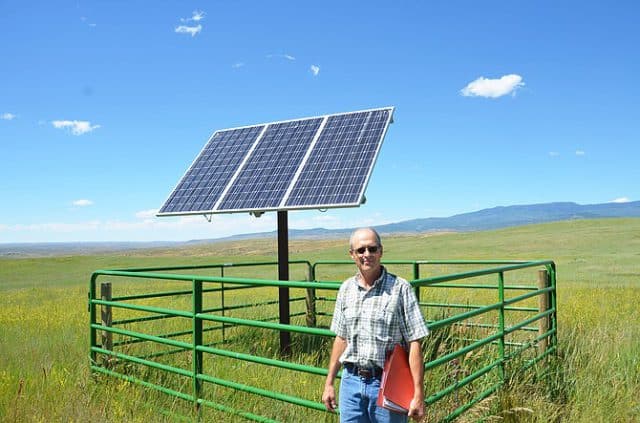 Photo by Michael Neary of Craig Daily Press. Vance Fulton, an engineering technician with the Natural Resources Conservation Service, stands next to a solar energy panel on the property of Doug Davis.